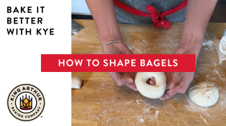 Hands shaping dough into a bagel